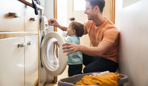 ojciec z dzieckiem robiący pranie