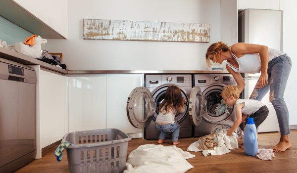 kobieta robiąca pranie razem z dziećmi