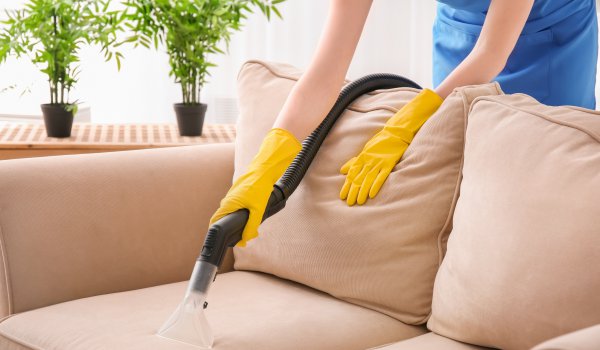 kobieta czyszcząca sofę