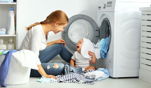 kobieta robiąca pranie z dzieckiem